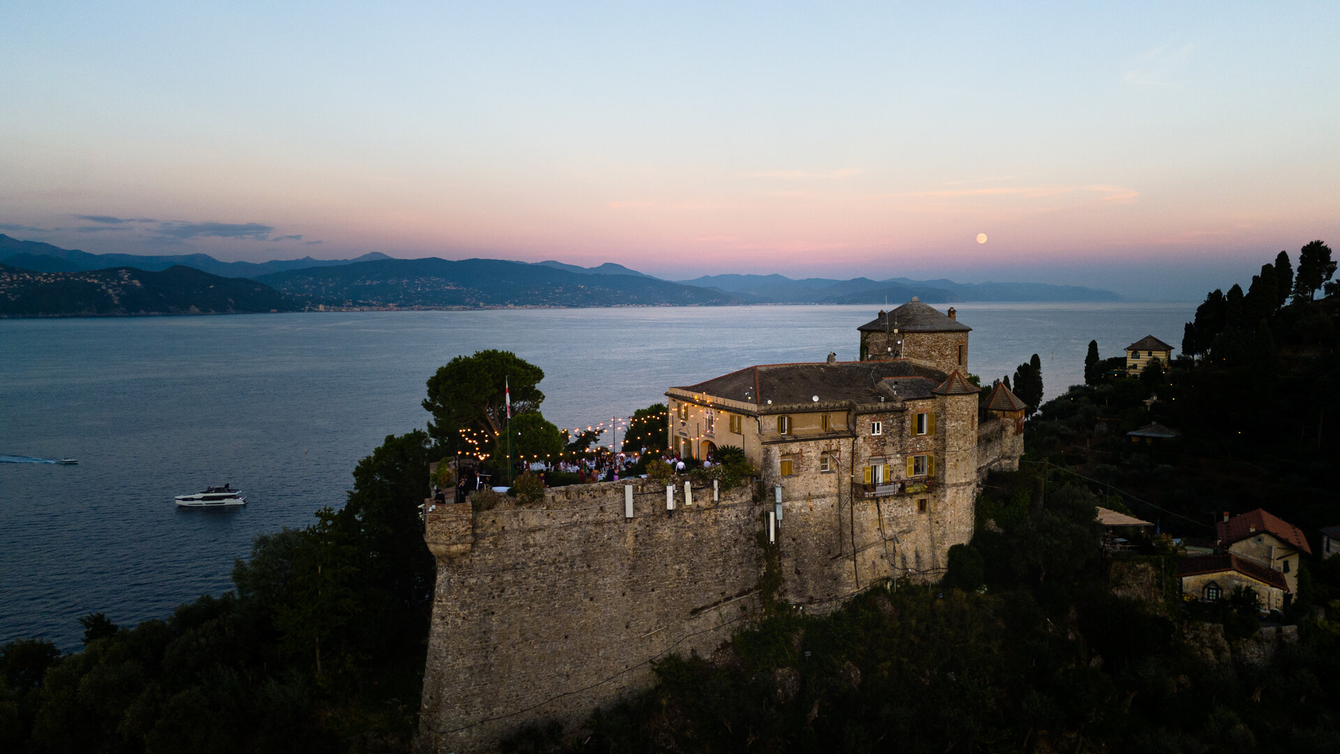 Castello sul mare al tramonto con ricevimento wedding, ripresa drone Milano